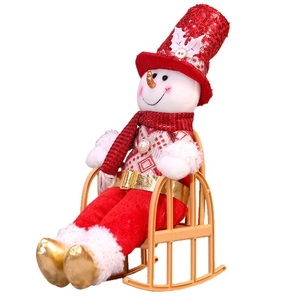 Christmas snowman doll with red sequin hat and striped scarf sitting on a beige rocking chair