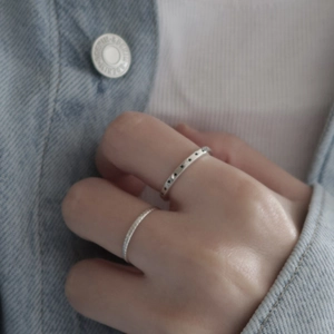 Detailed close-up of a 925 sterling silver star engraved ring and simple band set