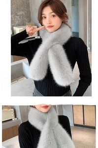 Detail of light gray faux fur scarf with a soft crossed design on a casual outfit