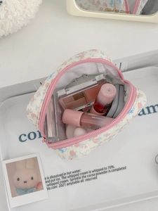 Détail macro de l'intérieur d'une trousse à fleurs remplie de rouges à lèvres et poudres