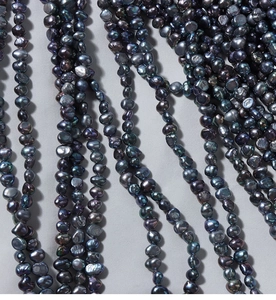 Detailed view of 4-5mm baroque natural freshwater pearls with iridescent peacock blue luster