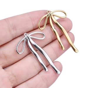 Detailed macro view of 304 stainless steel bow pendants in gold and silver finishes