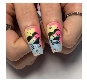Macro shot of long coffin fake nails with rainbow gradient, smile text and rhinestones
