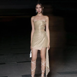Détail de la robe bustier dorée scintillante avec découpes à la taille et tissu brillant