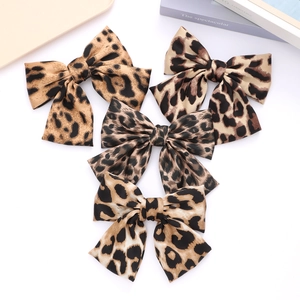 Set of four leopard print bow hair clips in satin fabric for stylish hair accessories