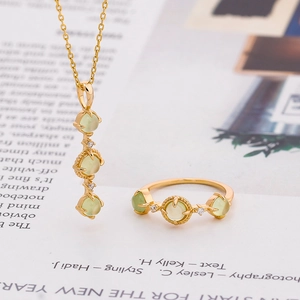 S925 silver necklace and ring set with natural green prehnite stones on a magazine background