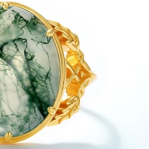 Macro detail of moss agate ring featuring green textures and golden leaf-shaped setting