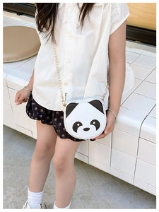 Detail view of cartoon panda shoulder bag with gold chain strap on small child model