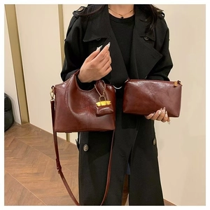 Classic deep red vintage oil wax leather handbag set with gold hardware on black coat