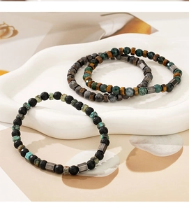 Three-piece men's natural tiger eye and agate beaded bracelet set on stone props