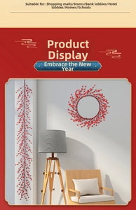 Detailed view of artificial red berry wreath and long vine hanging on a white wall decor