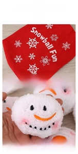 Close-up of plush snowball toy with embroidered face and red festive storage bag