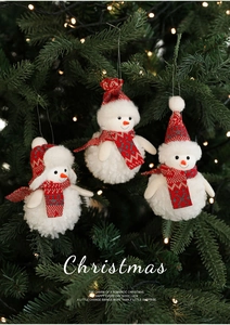 Detailed plush snowman ornaments with red and grey knit hats on a Christmas tree