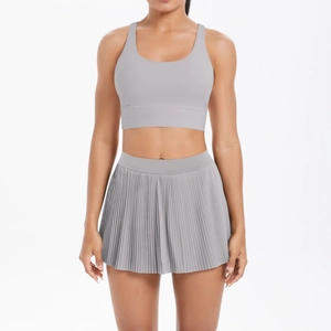 Detail view of light grey pleated tennis skirt and u-neck sports bra set in high elastic fabric