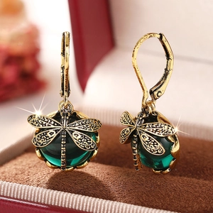 Nahaufnahme der Libellen-Ohrringe im Vintage-Look mit grünen Perlen und Gold-Flügeln