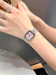 Detail of silver square watch with gradient pink dial and mesh band on female wrist
