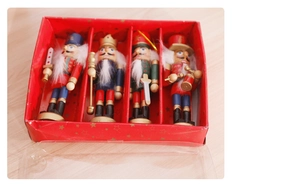 Set of four handcrafted wooden Nutcracker ornaments in a festive red star gift box