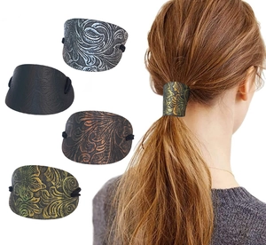 Detailed views of vintage leather ponytail holders with diverse embossed floral patterns