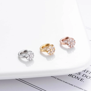 Detailed view of floral zircon earrings in gold, silver and rose gold finishes