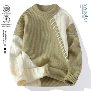 Detail eines grün-beigen Rippstrickpullovers mit weißer Kreuznaht auf der Brust
