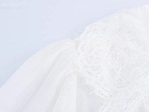 Détail de la broderie en dentelle blanche et du tissu en tulle transparent sur la robe