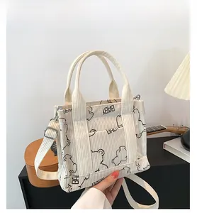 Detail of cream corduroy tote bag with bear print and adjustable crossbody strap
