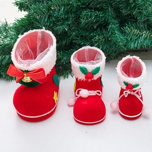 Three sizes of red flocked Christmas candy boots with white trim and golden bell ornaments
