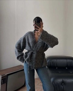 Dettaglio del cardigan in maglia grigia con cintura coordinata per uno stile casual