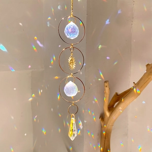 Detail of sun catcher with crystal spheres and sun charm reflecting rainbow light on wall