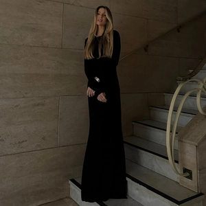 Elegant black long-sleeved bodycon dress shown on model standing on marble steps