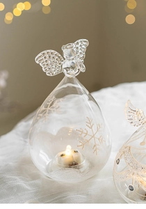 Detail of angel glass ornament with etched snowflakes and warm LED candle light glowing