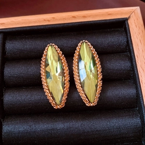 Detail of marquise cut yellow-green gemstones with gold beaded borders in a display box