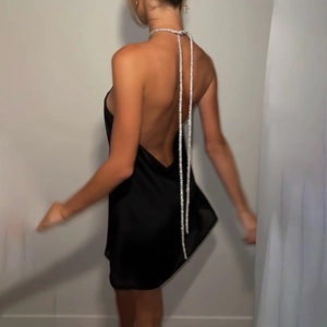 Détail d'une robe noire dos nu sexy avec une chaîne élégante en strass argentés