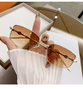 Detail of vintage gold metal square sunglasses with gradient brown lenses and slim temples