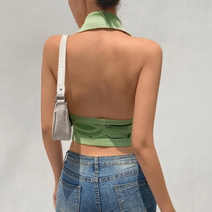 Dettaglio del top in maglia verde con scollo all'americana e design senza schienale