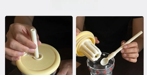 Close-up of heat-resistant glass cup accessories including lid, straw, filter and spoon