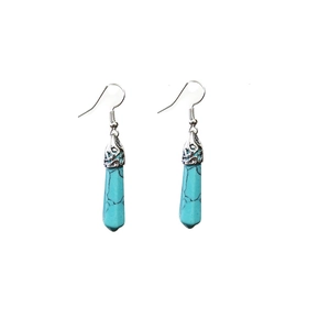 Detail of bohemian turquoise hexagonal pillar earrings with vintage engraved silver caps