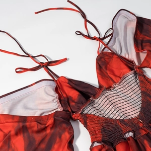 Close-up of smocked back and adjustable tie straps on red floral tie-dye mini dress