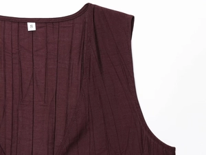 Macro detail of wine red pleated tank top showing crinkle fabric texture and neckline