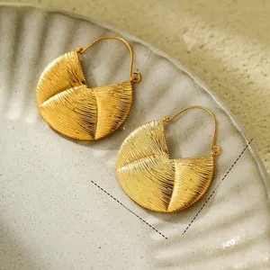 Detail view of 18K gold plated titanium steel earrings with radial brushed texture