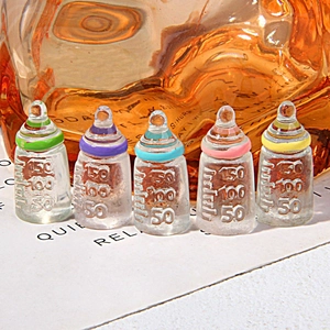 Five miniature resin baby bottles with colorful macaron rings and scale markings