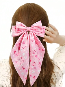 Detailed back view of pink satin bow hair clip with LOVE heart prints on a model