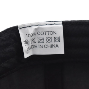 Detail showing the 100% cotton material label and care instructions on the baseball cap