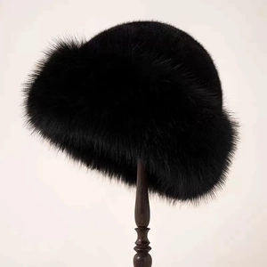 Close-up of a luxury black faux fur winter hat displayed on a wooden stand