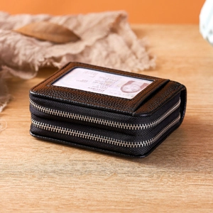 Black lychee leather RFID card wallet with dual zippers and ID window on a wooden table