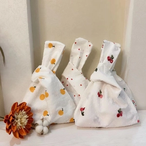 Detailed close-up of Japanese knot bags with orange, heart, and cherry patterns
