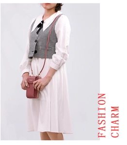 Detail of pink pebbled leather crossbody phone bag with zipper and adjustable shoulder strap