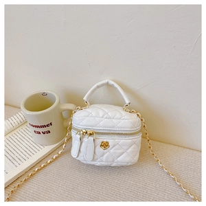 Detailed view of white quilted mini bag with gold flower clasp and chain strap