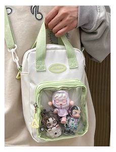 White and green ita bag with clear window shown on shoulder for displaying collectibles