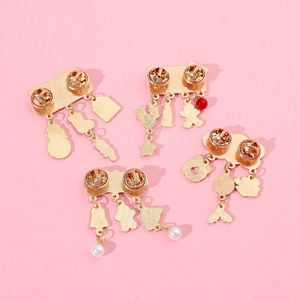 Back view of gold Christmas brooches with snowflake and gingerbread man charms